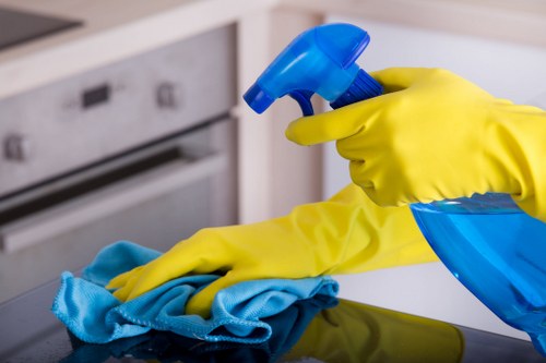 Cleaner wearing PPE and working safely in a professional cleaning environment